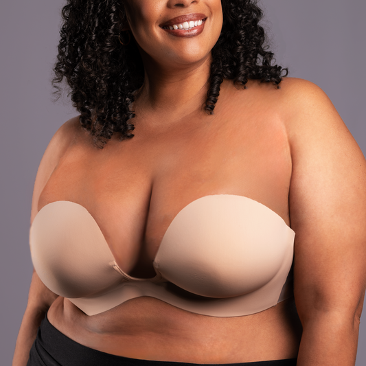 Model wearing the Voluptuous U Plunge Backless Strapless bra, showing how it can provide lift and coverage at any size. Bra is beige in color.