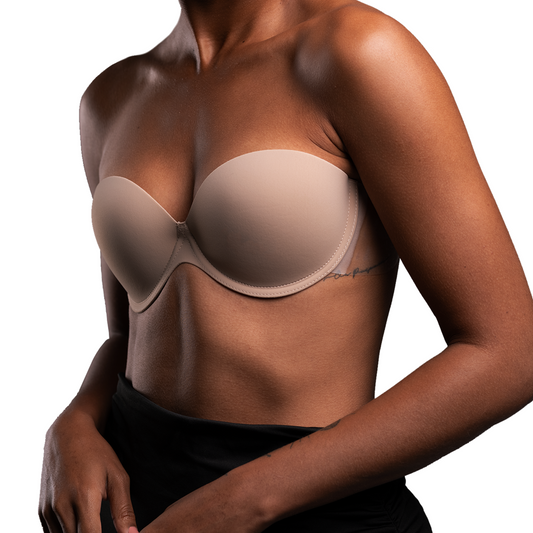 Model stands at a slight angle wearing the Go Bare Backless Strapless Bra, showing how it secures to the body. Bra is beige.