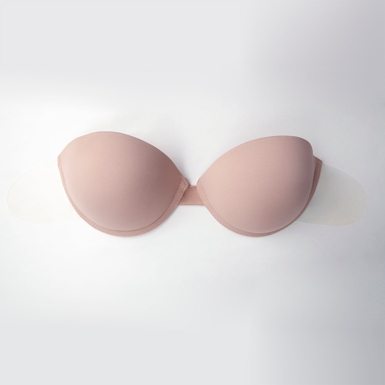 Product image of the go bare ultimate boost bra, not on model. The outside is facing the viewer. You can see how the cups are not touching, but held together by a small band in the middle, underwire, and the adhesive flaps on the side. Bra is beige.