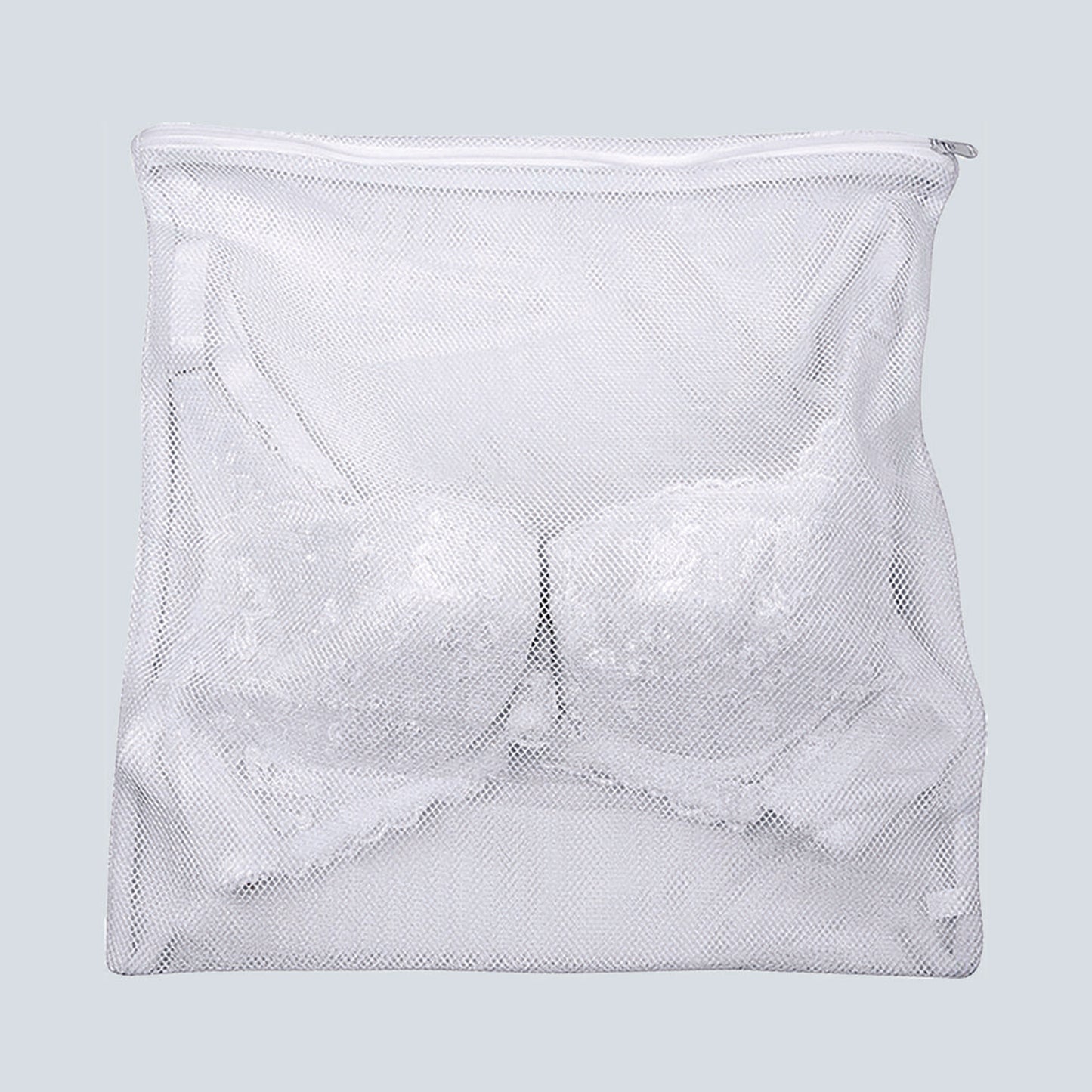 Close up image of the lingerie laundry bag. A lace bra is inside the bag to show how your bra will fit in it. The bag is white mesh.