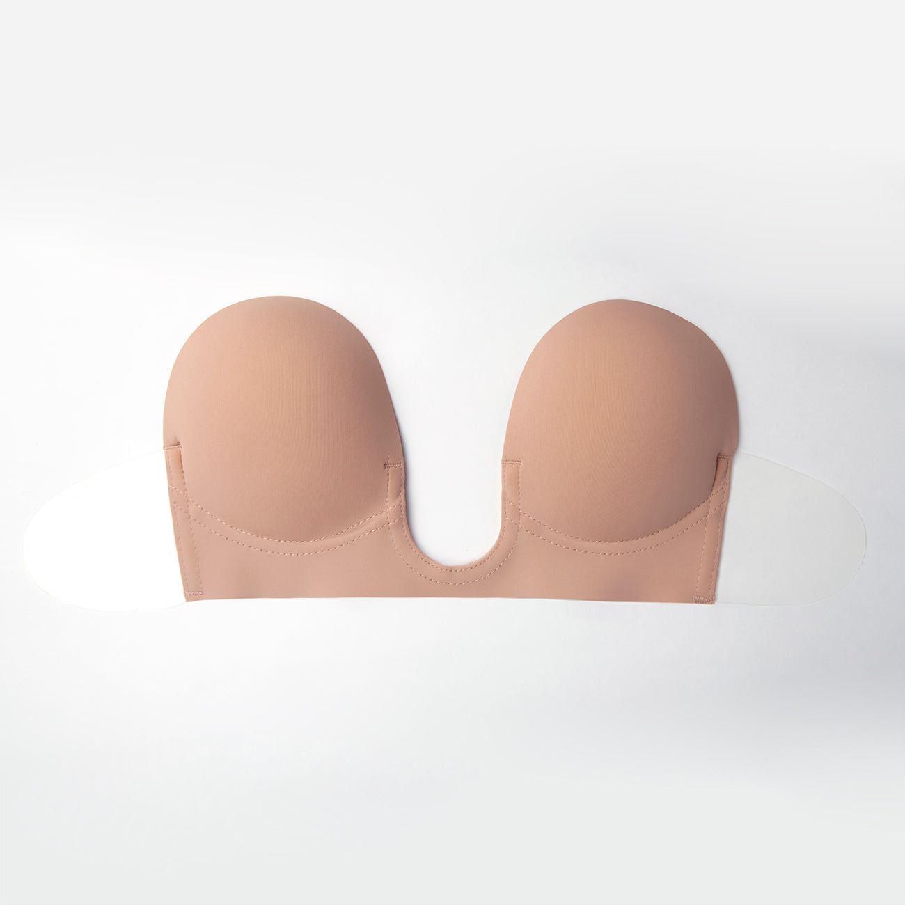 Product image of the nude U Plunge Backless Strapless bra. It is soft and has adhesive flaps on the side